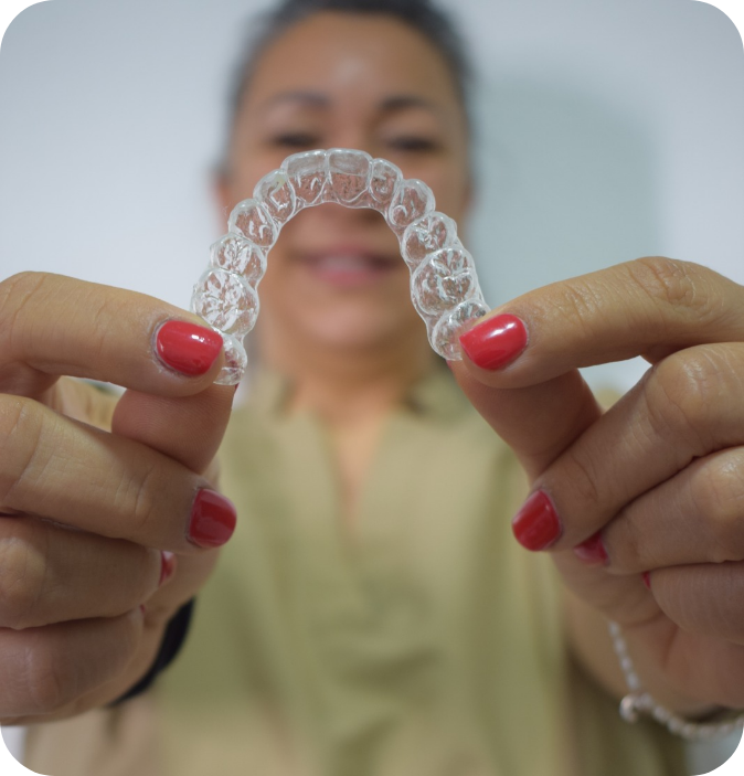 Doctora sosteniendo alineador invisible ortodoncia CGB